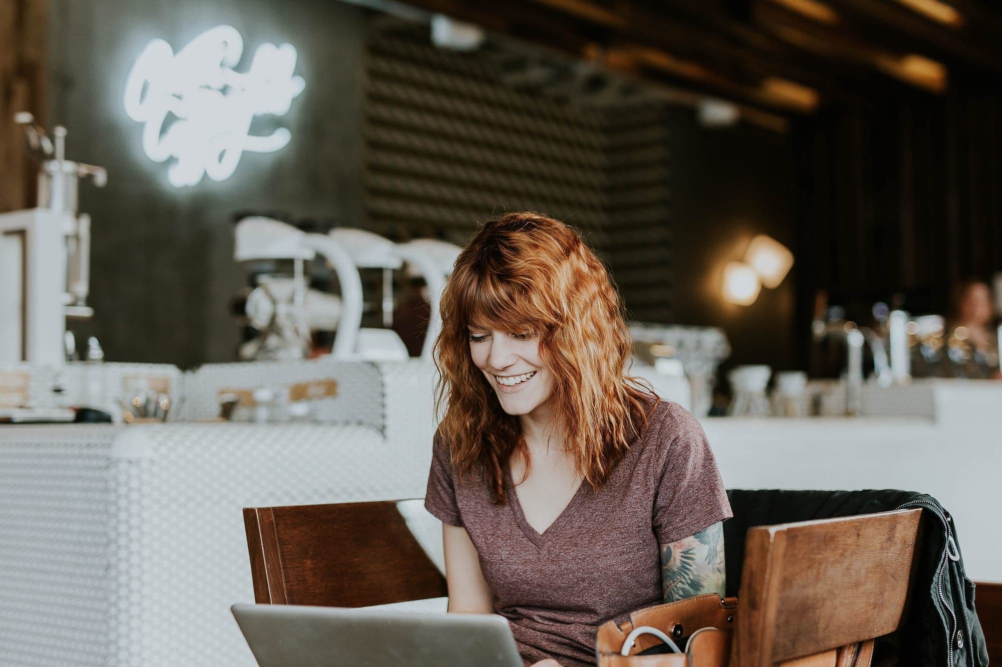 Smiling woman working on a laptop in a café